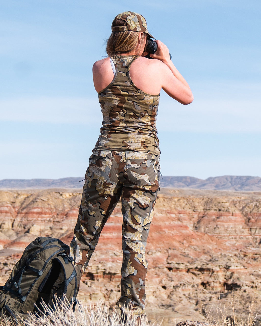 Female hunter glassing on top of bluff in hot weather wearing Women's Tiburon Pant in Valo Camouflage