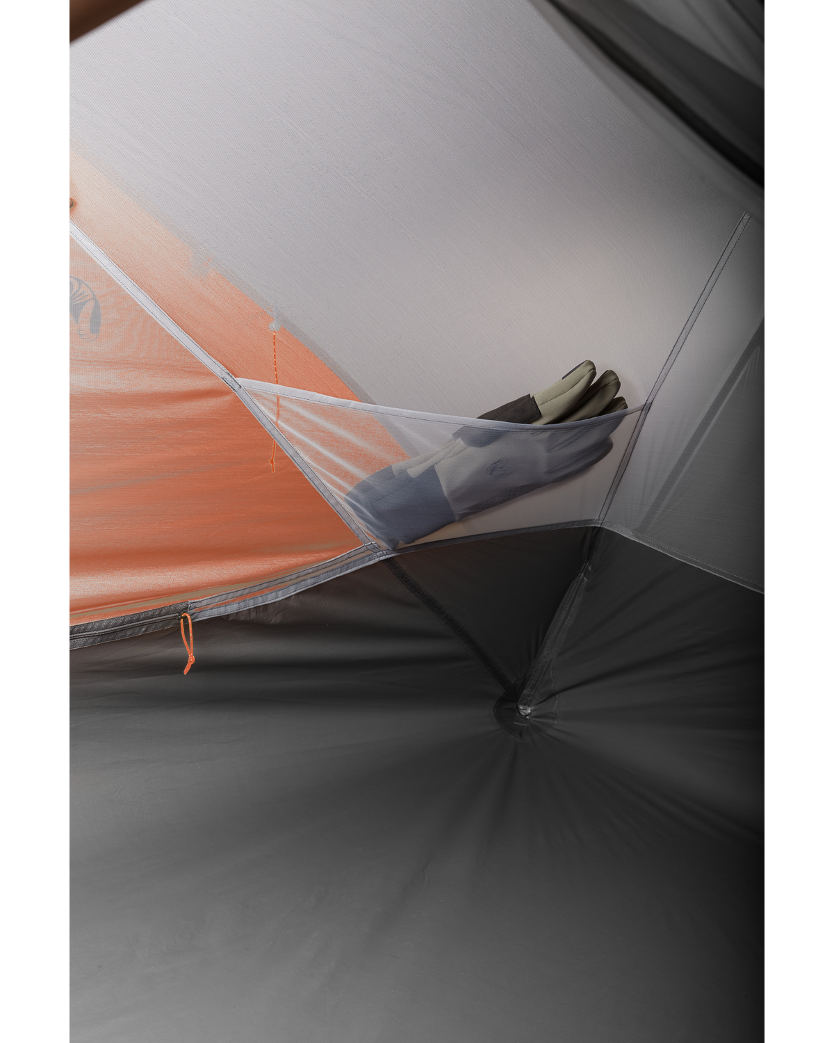 a pair of glove tucked inside internal storage pocket in the Mountain Star 2 Person Tent in Gunmetal Grey, Orange