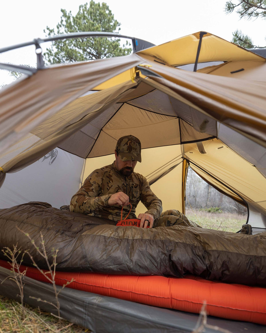 Image showing a seated hunter inside of the Mountain Star 3 Person Tent to show the amount of headroom inside of the tent while seated upright