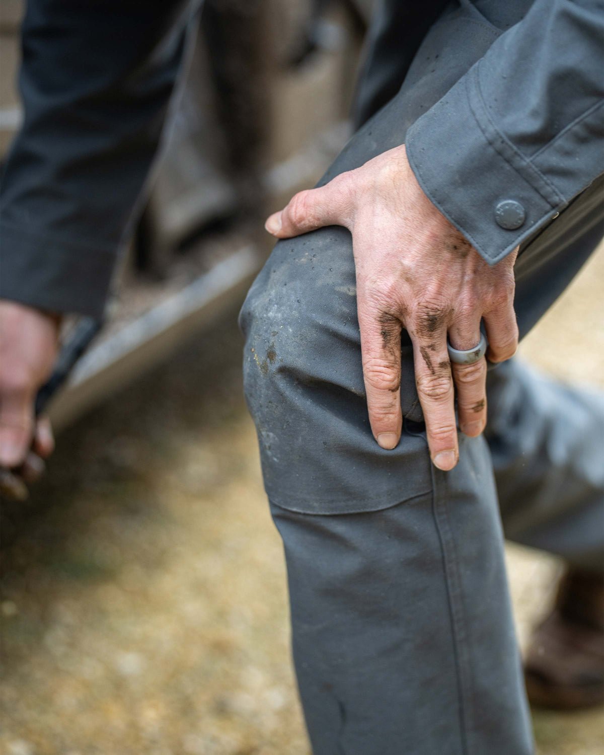 Close-up of man bending his knee forward, highlighting double panel overlay on the knees on Brawley Pant in Gunmetal Grey