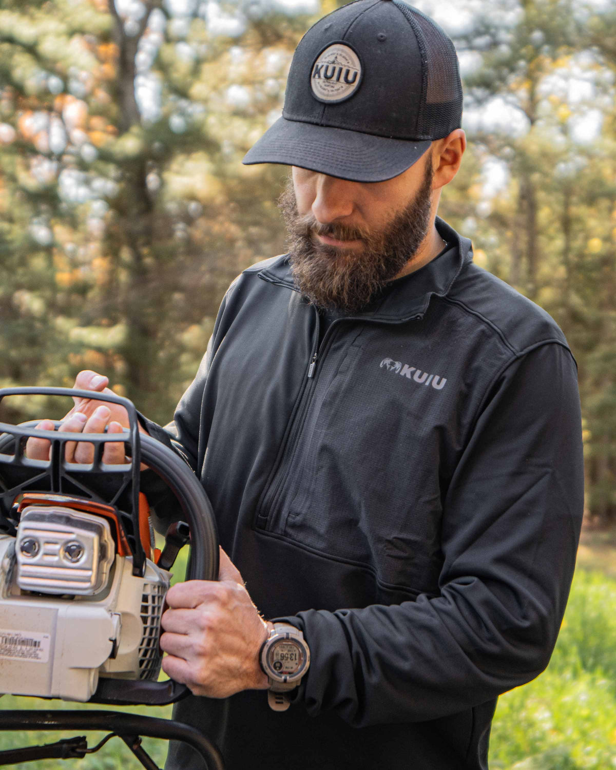 Hunter wearing the Bicomp Zip-T in Black holding a chainsaw