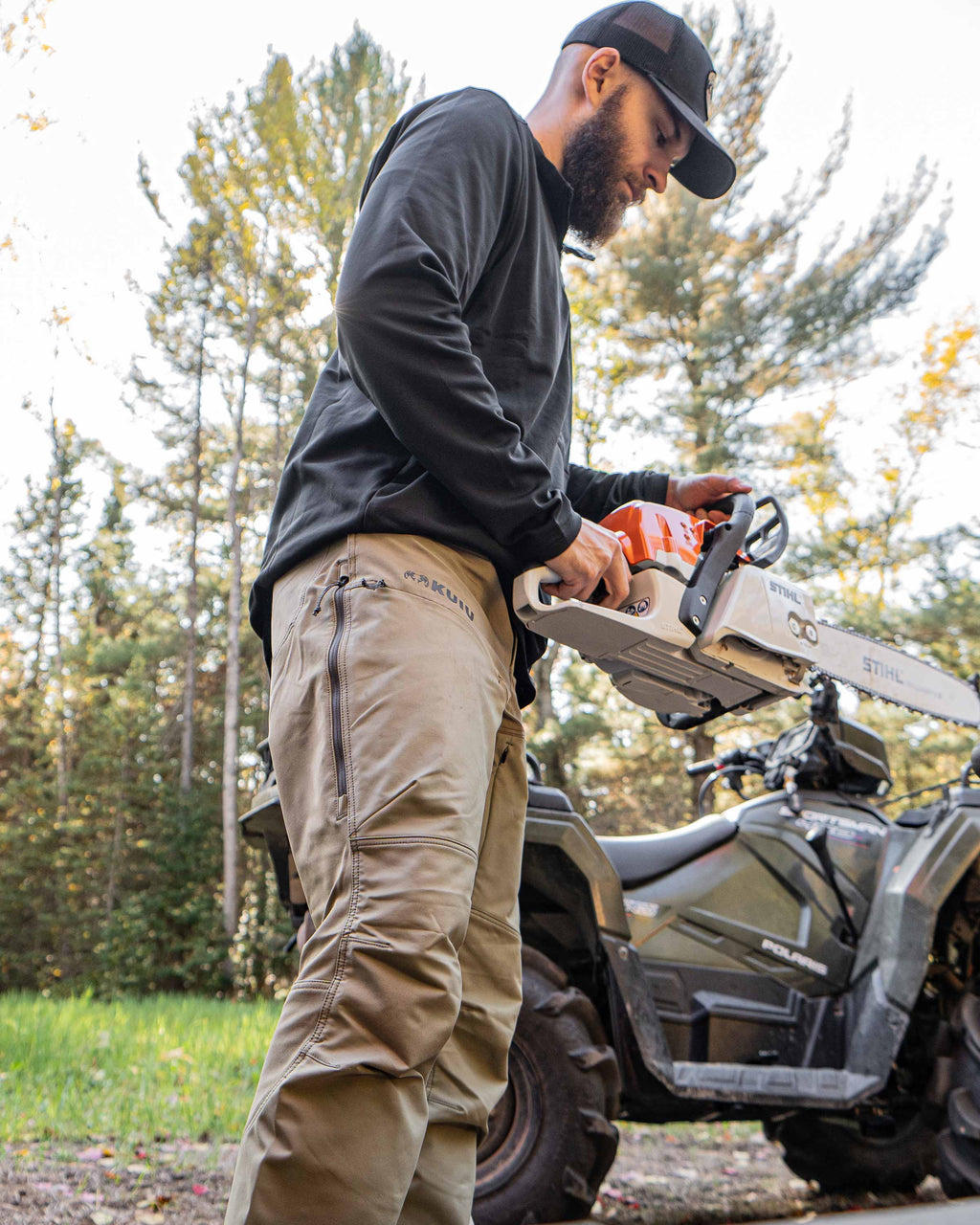 Hunter wearing Bicomp Zip-T in Black holding a gas chainsaw