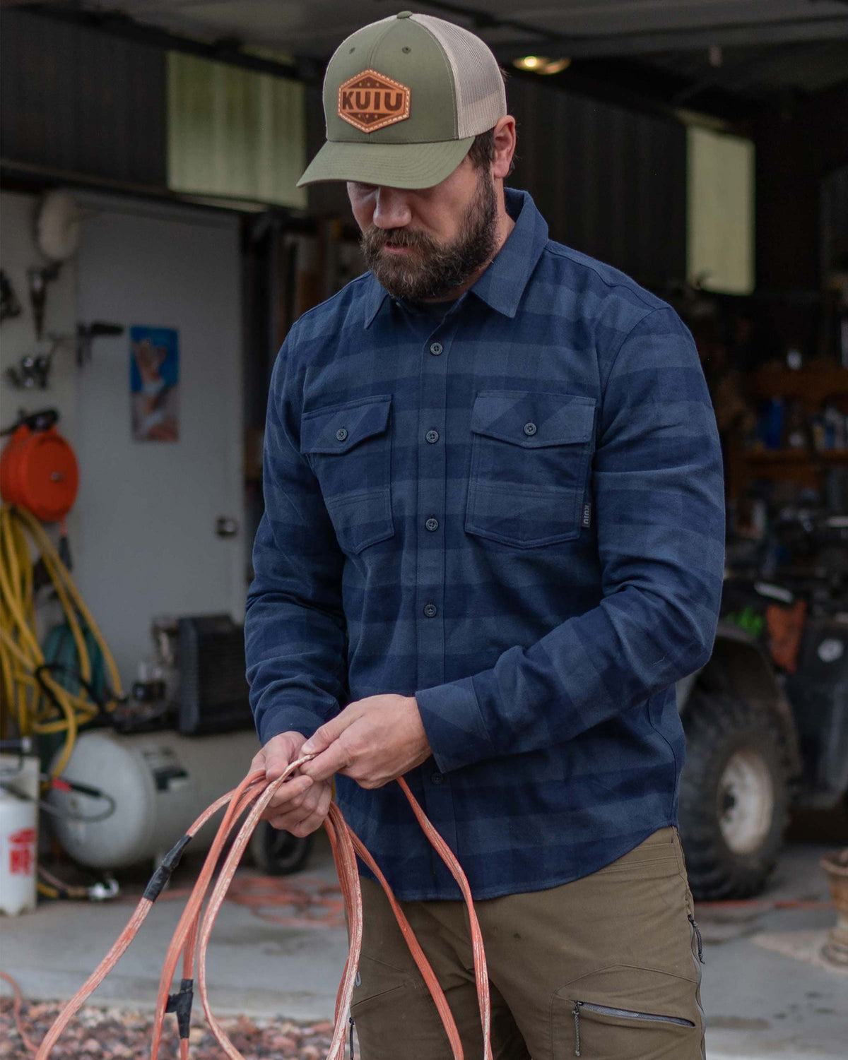 Man outside organizing cords wearing Field Flannel Shirt in Steel Blue Buffalo Check