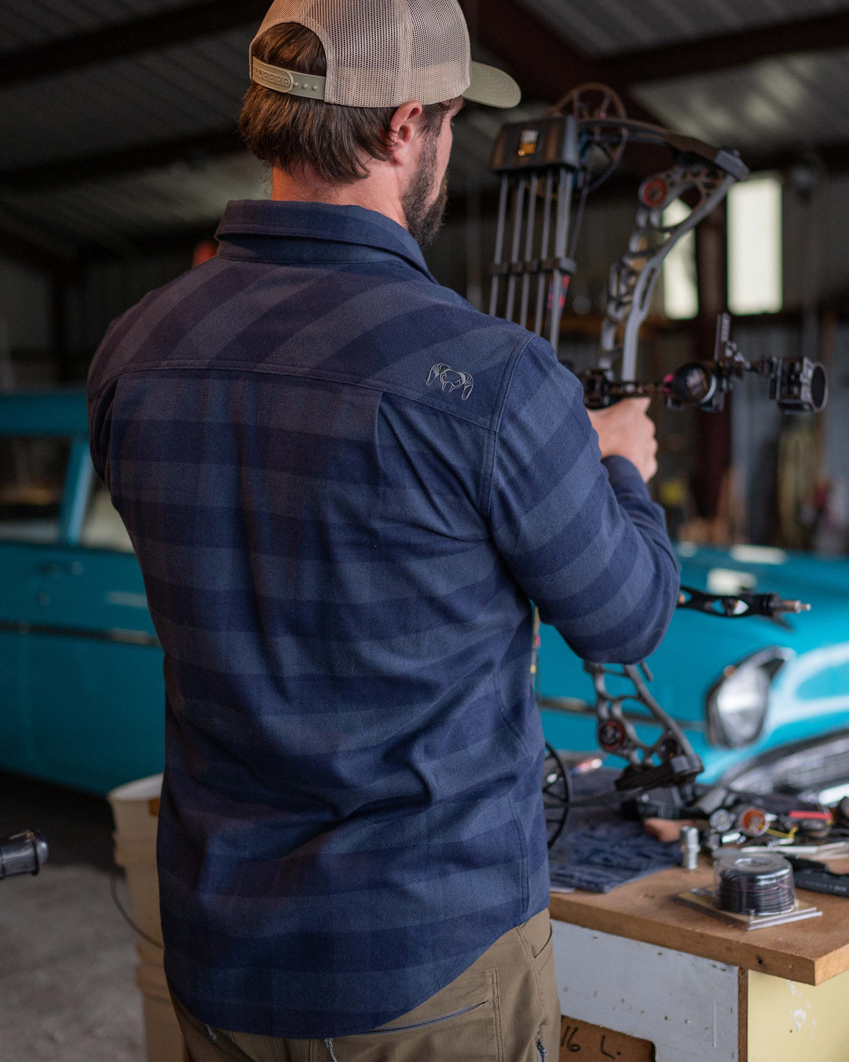 Man holding compound bow showing back of Field Flannel Shirt in Steel Blue Buffalo Check