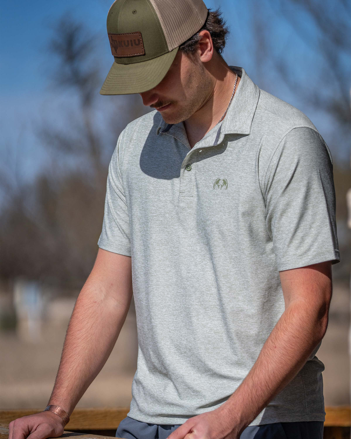 Hunter in the field wearing KUIU Performance Polo T-Shirt in Heather Buckbrush