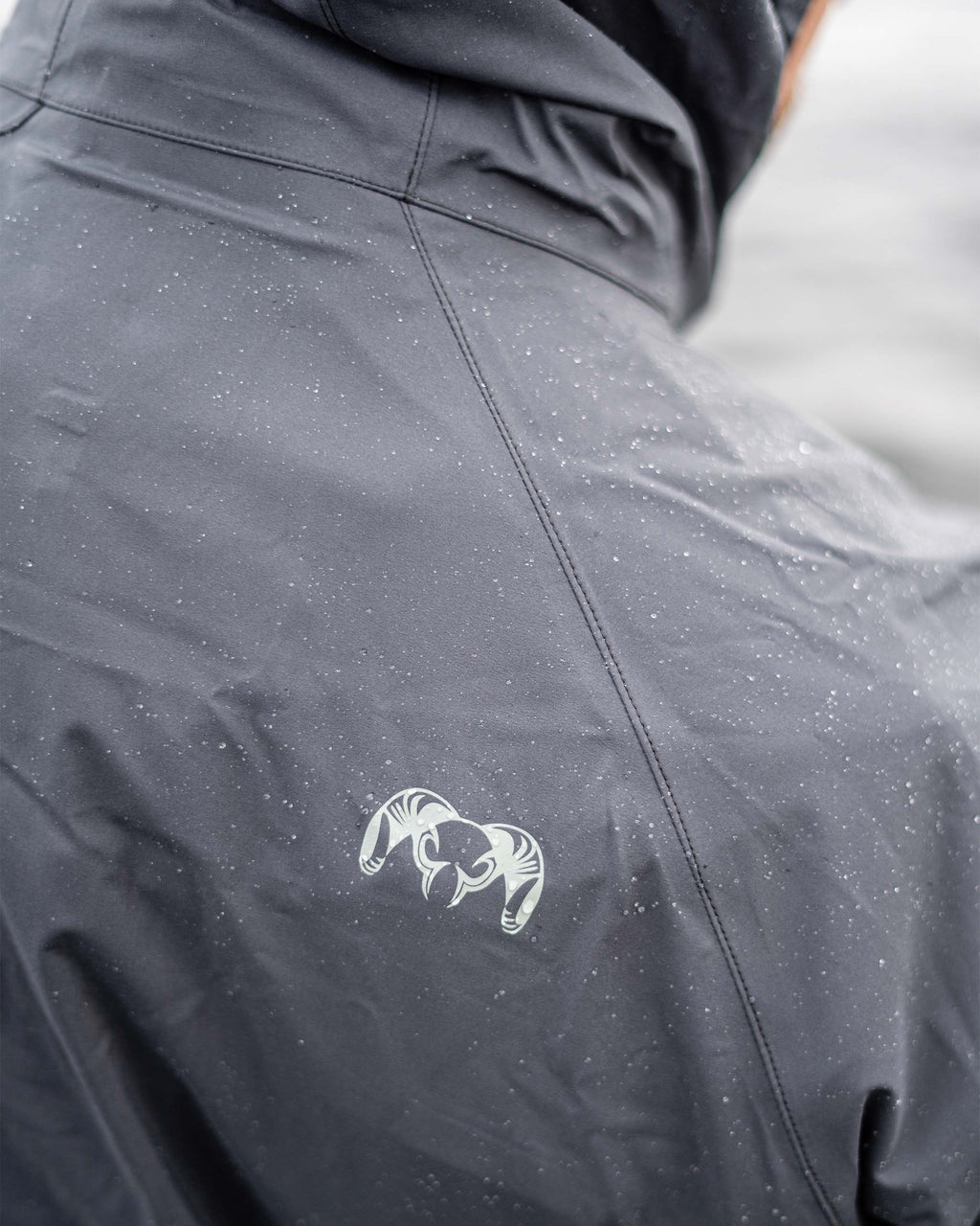 Back shoulder detail of KUIU Ram Logo on the Northridge Rain Jacket in Gunmetal Grey