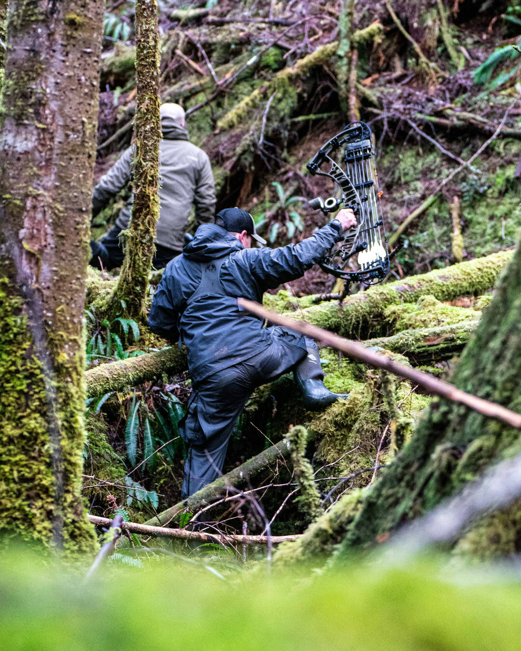 Hunters hiking through a deep forest covered in moss, wearing Northridge Rain Jacket and Pant in Gunmetal Grey
