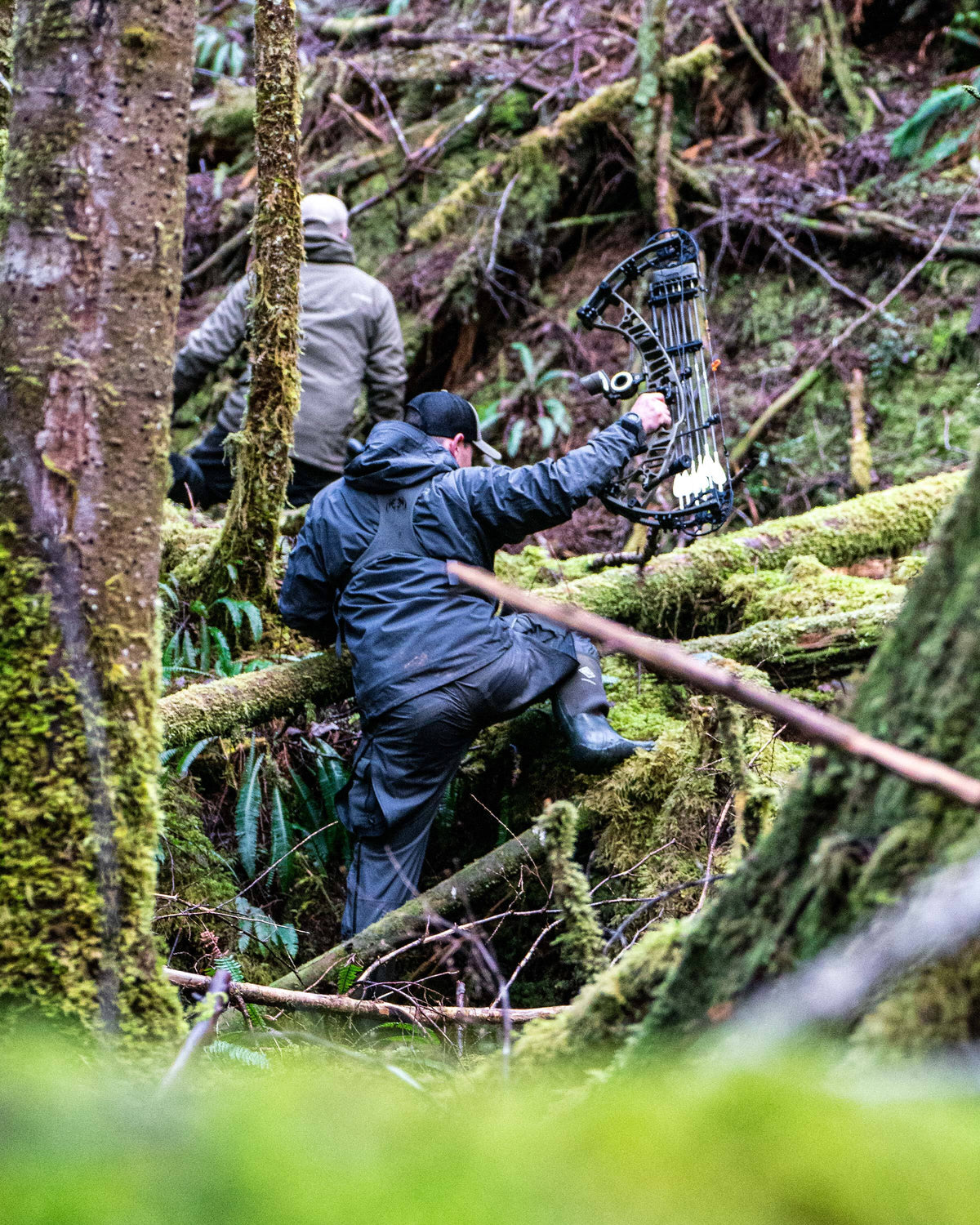 Hunters hiking through a deep forest covered in moss, wearing Northridge Rain Jacket and Pant in Gunmetal Grey
