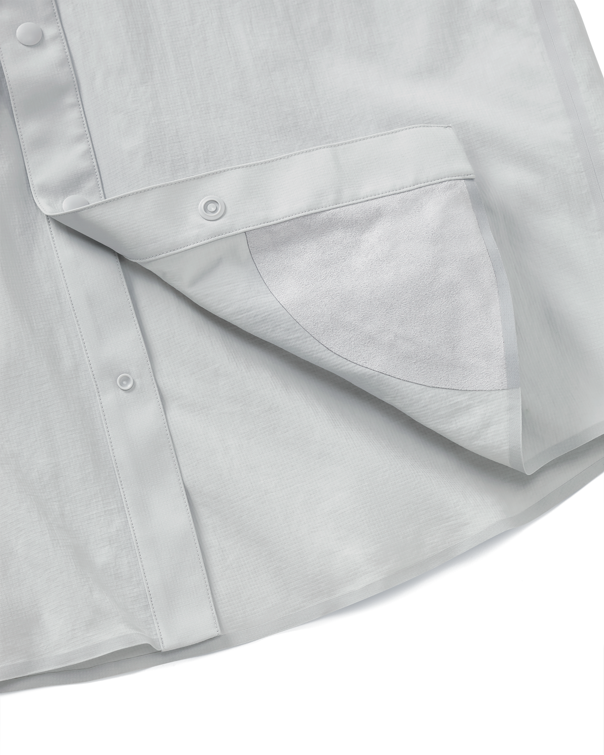 Detail view of integrated micro-fiber lens cleaning cloth patch sewn on the inside lower hem of the Salton Long Sleeve Shirt in Lunar Grey
