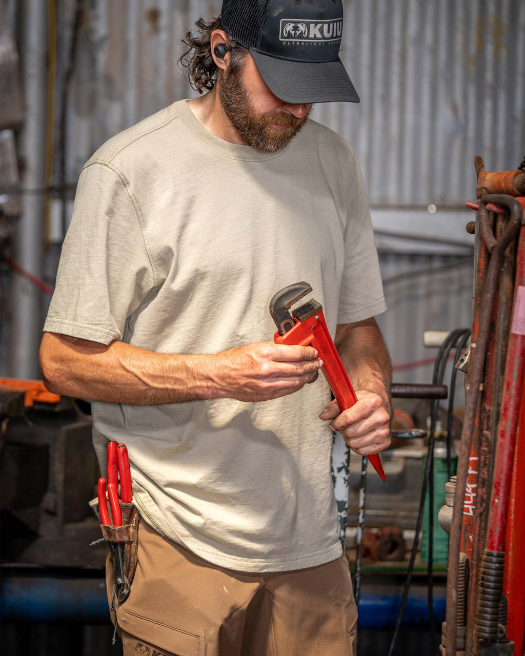 Man in his workshop holding a wrench wearing Workgrade Short Sleeve in Bone Khaki