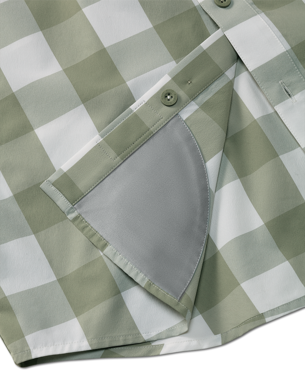 Detail view of integrated micro-fiber lens cleaning cloth patch sewn on the inside lower hem of the Borrego LS Shirt in Sage Buckbrush Plaid