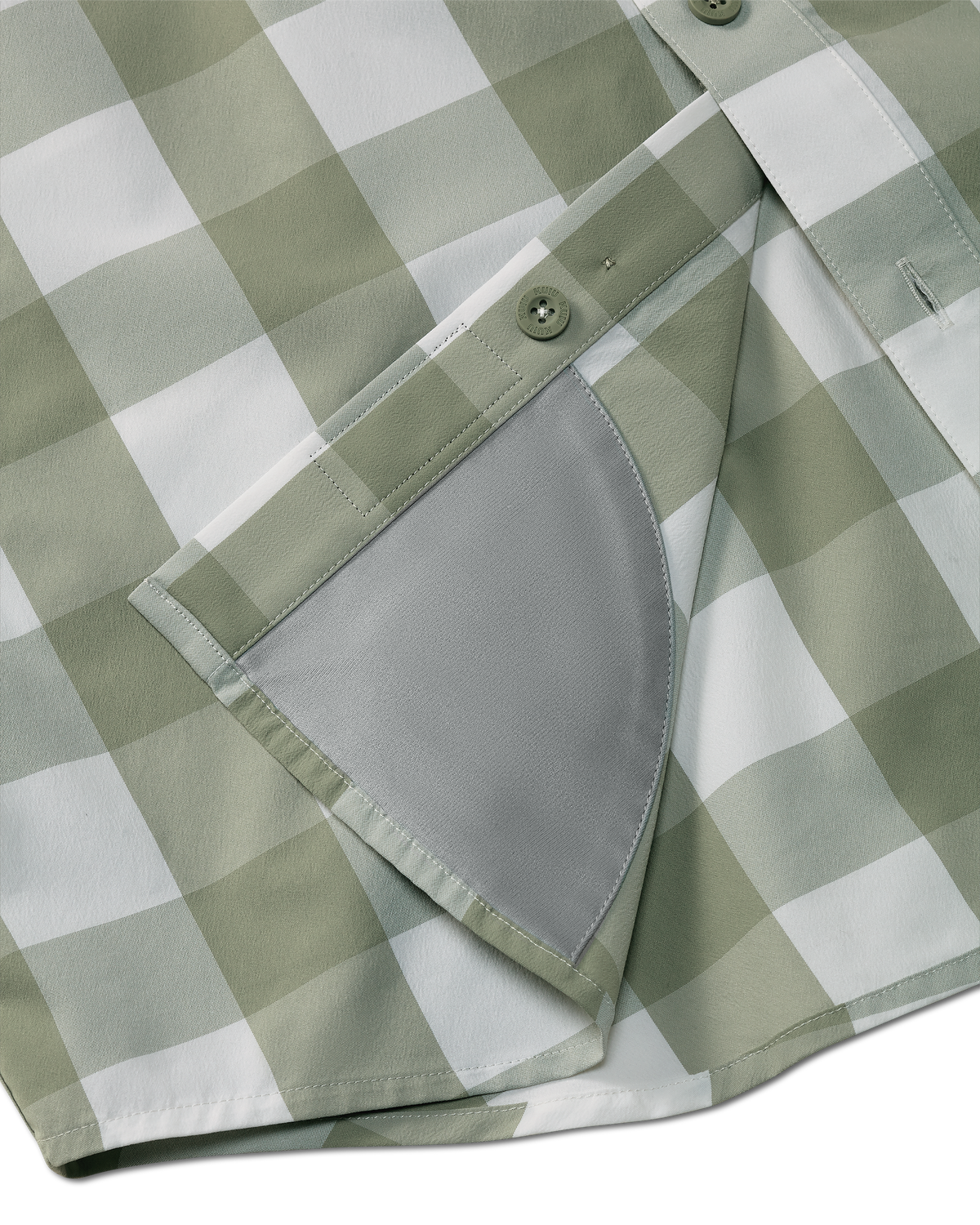 Detail view of integrated micro-fiber lens cleaning cloth patch sewn on the inside lower hem of the Borrego LS Shirt in Sage Buckbrush Plaid