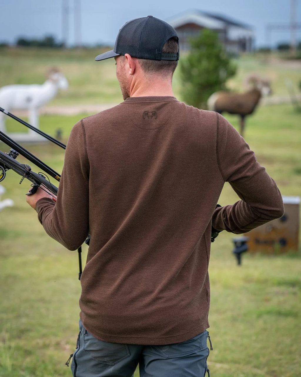 Back of hunter preparing to use his bow wearing Canyon Waffle Henley Shirt in Cedar Heather Brown