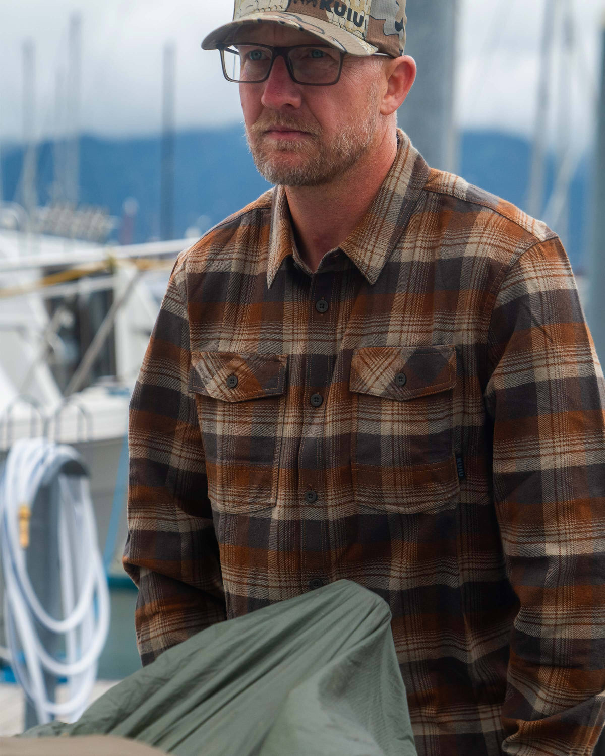 Man gazing into the distance while wearing the Field Flannel Shirt in Saddle Blockline