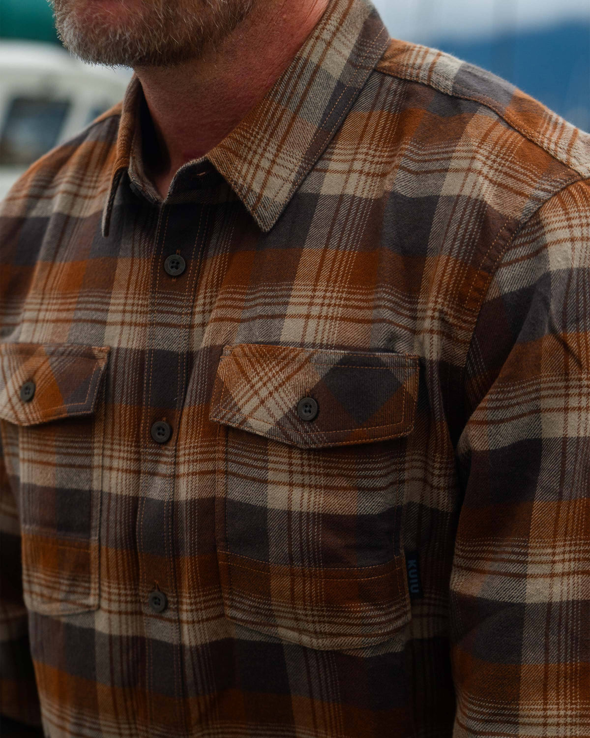 Close-up shot of man wearing Field Flannel Shirt in Saddle Blockline, Highlighting fabric texture and chest pockets 