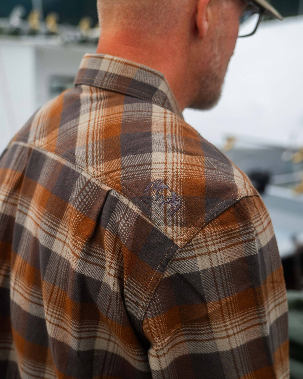 Back shoulder view of Field Flannel Shirt in Saddle Blockline, Highlighting embroidered KUIU Ram Logo