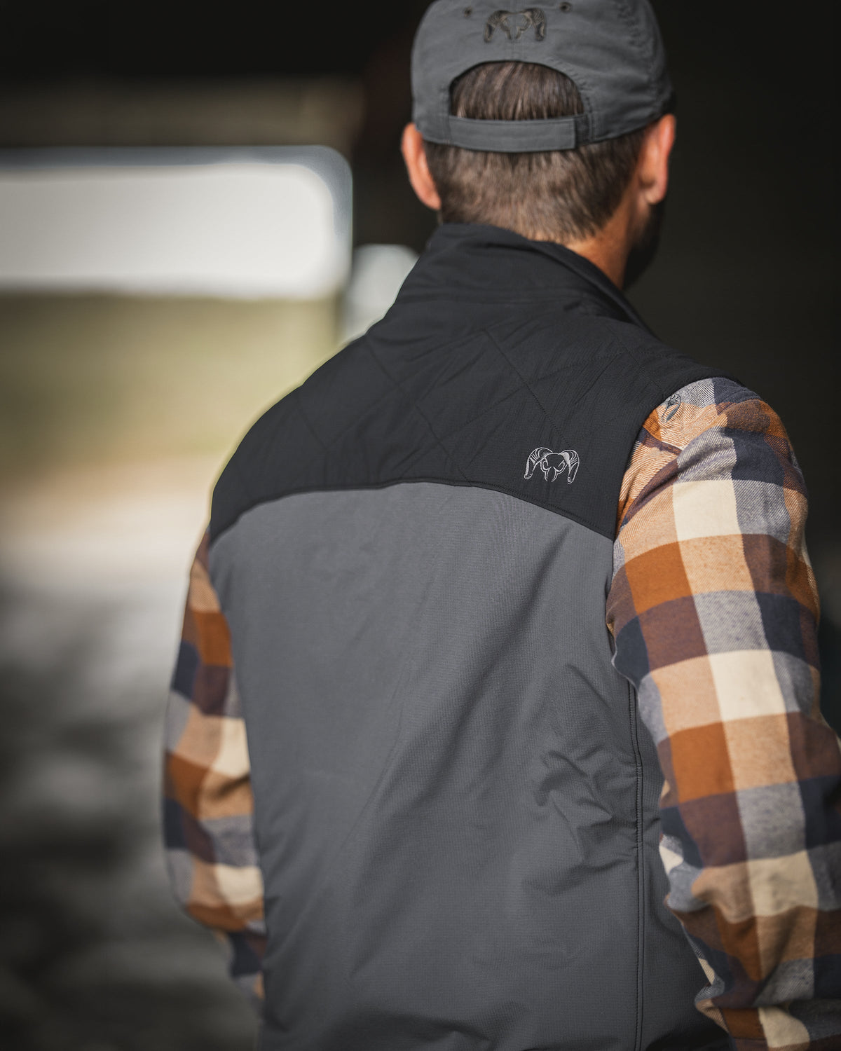 A man viewed from behind wearing Transit Packable Vest in Black/Gunmetal.