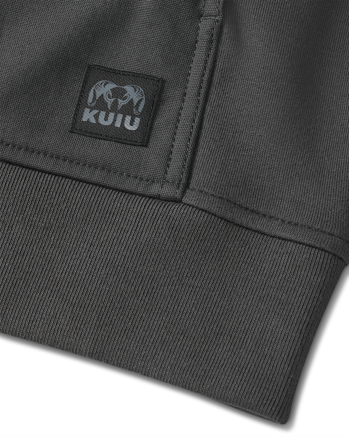 Detail of sewn-on KUIU logo patch located on the bottom of Workgrade Utility Hoodie in Asphalt Grey