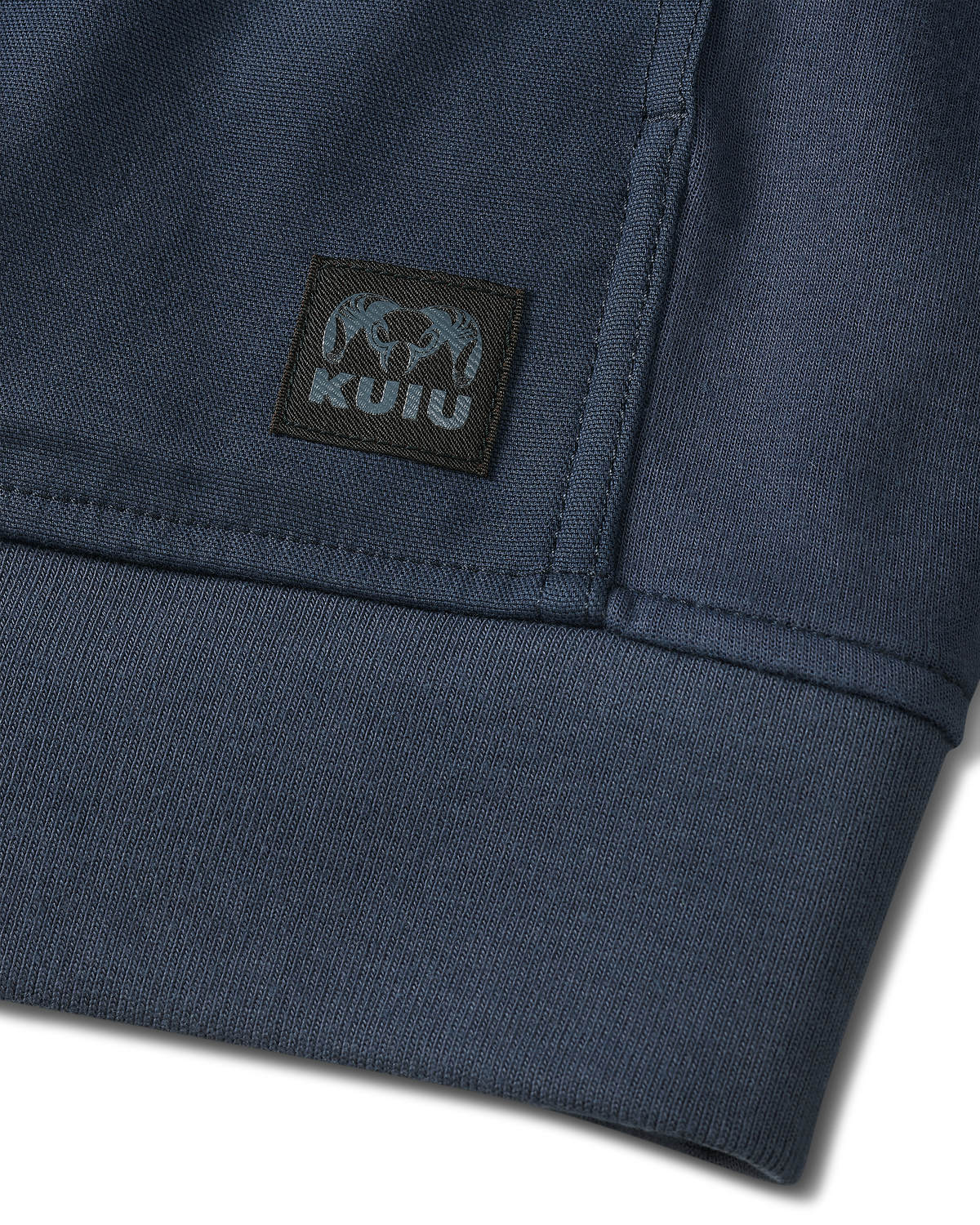 Detail of sewn-on KUIU logo patch located on the bottom of Workgrade Utility Hoodie in Steel Blue