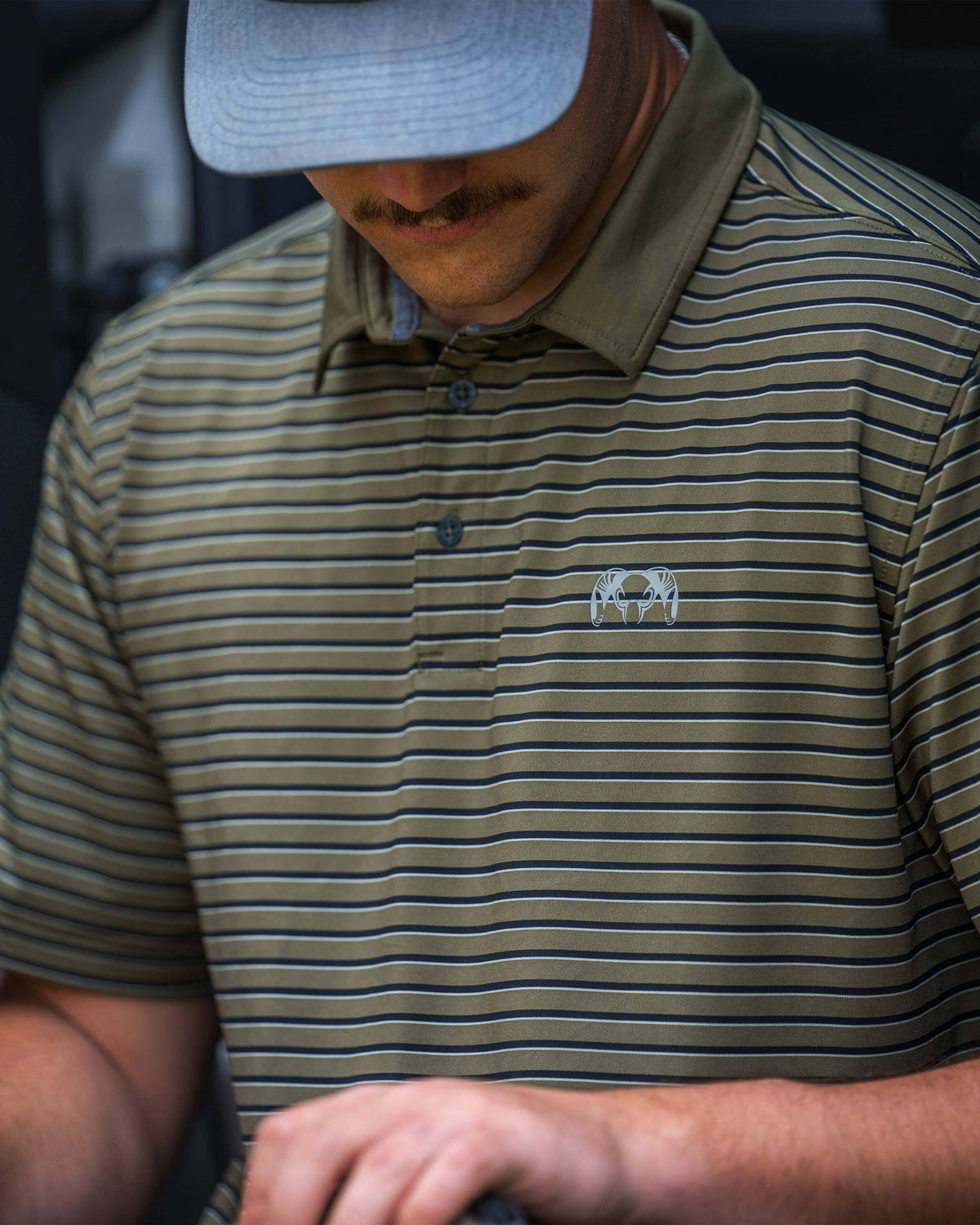 Close-up of man wearing KUIU Performance Polo in Evergreen Stripe