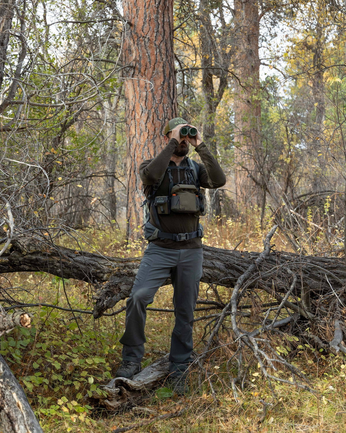 Hunter glassing in the middle of the forest, wearing Ultra Merino 145 Zip-T Hunting Shirt Loden Green