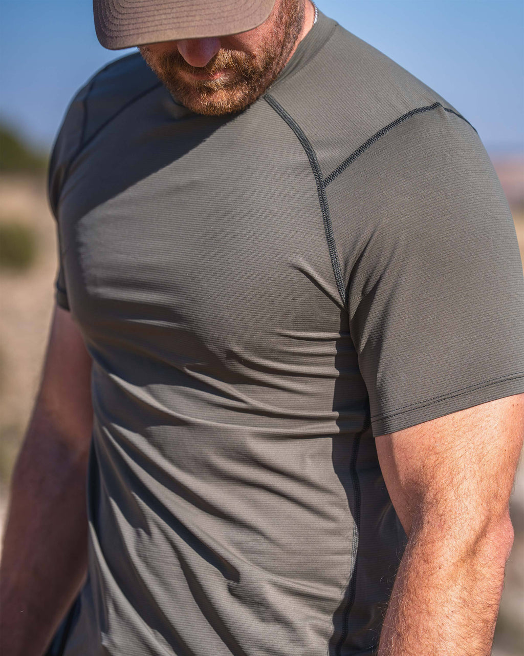 Hunter in an outdoor environment wearing Vital S1 Short Sleeve in Ash Brown, showcasing hybrid raglan sleeve.