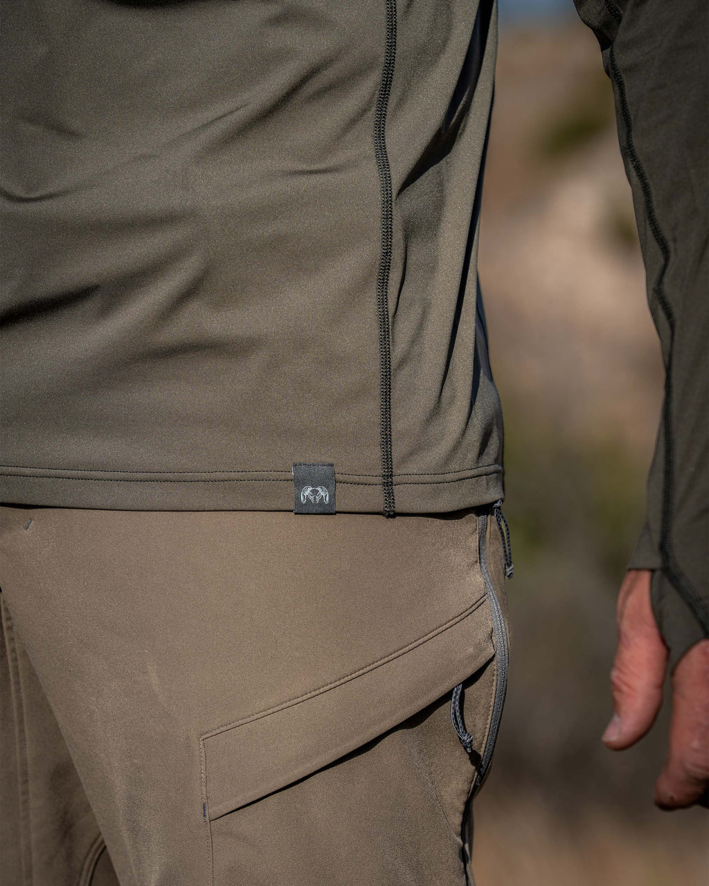 Close-up of Vital S2 Zip-T in Ash Color with a focus on the fabric texture, flat lock seam and bottom hem.