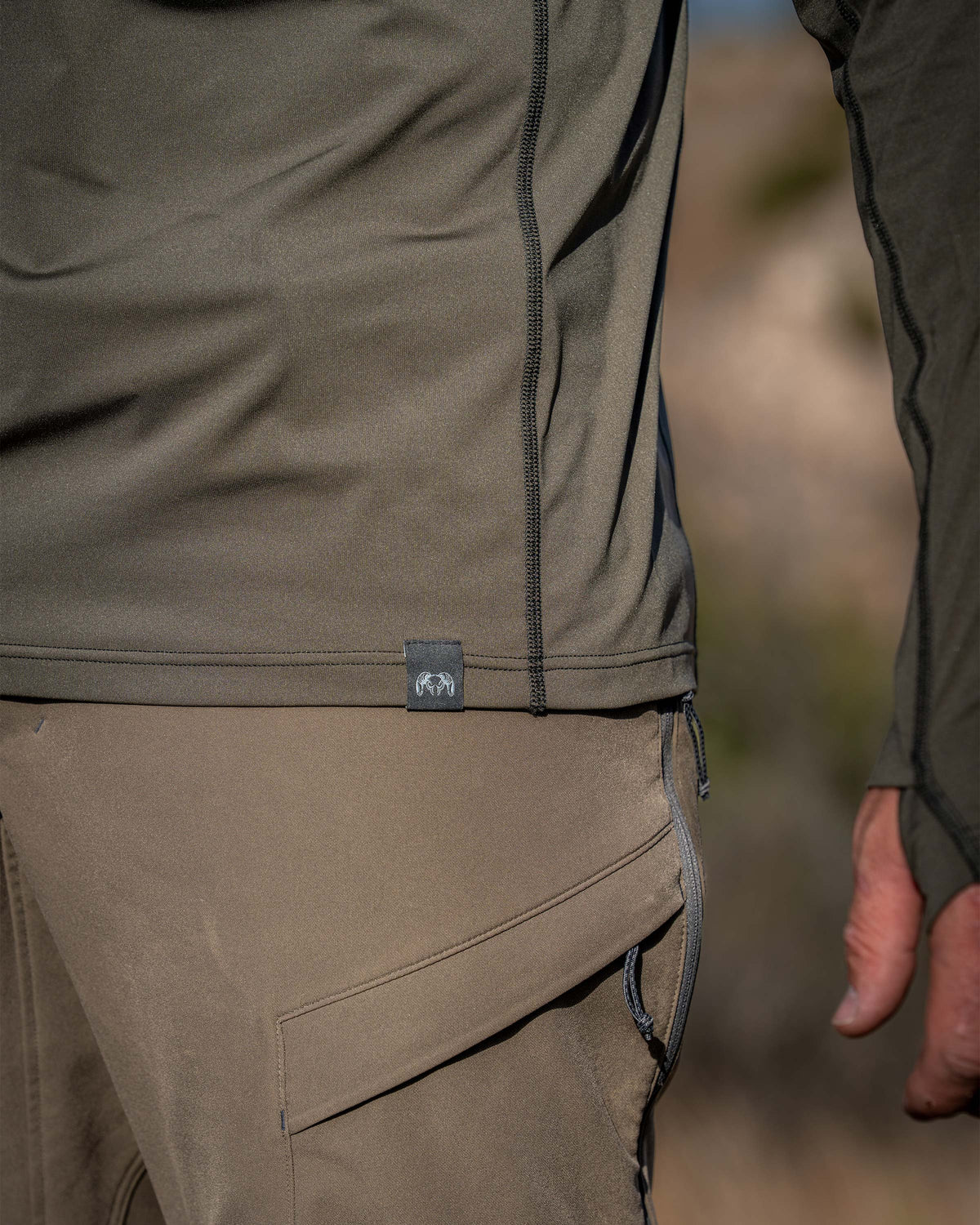 Close-up of Vital S2 Zip-T in Ash Color with a focus on the fabric texture, flat lock seam and bottom hem.