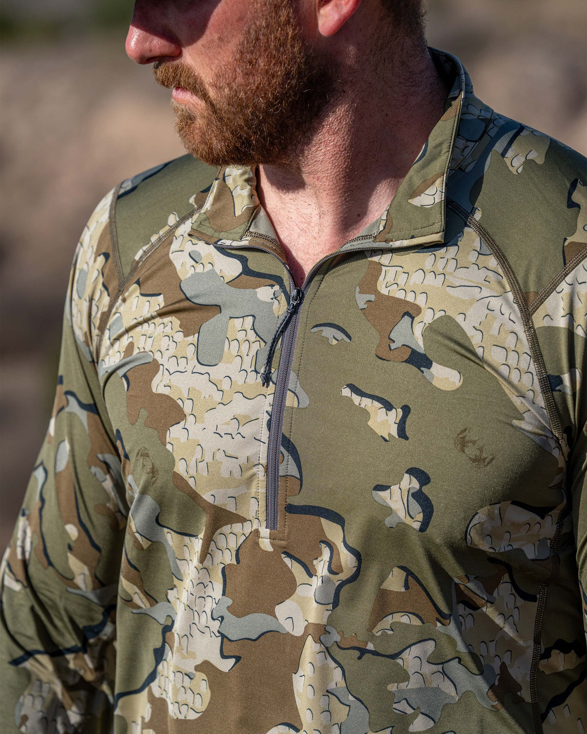 Close-up of hunter wearing Vital S2 Zip-T in Valo Camouflage, highlighting front half zip.