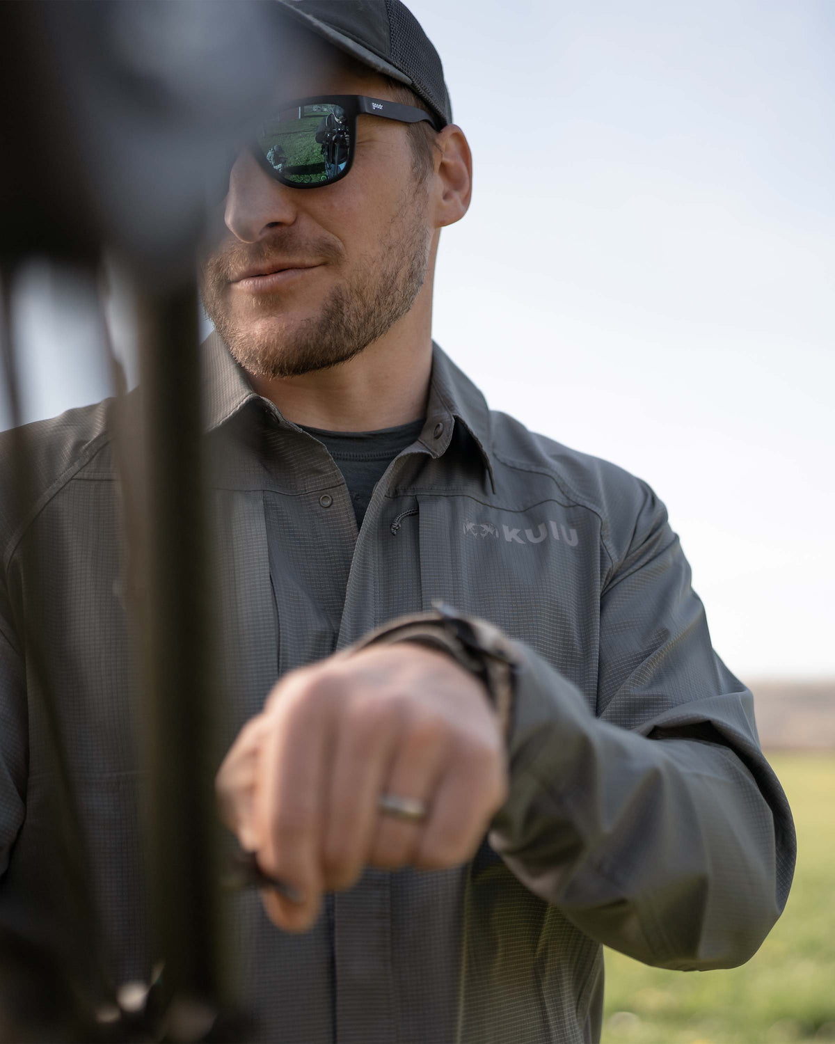 Hunter pulling back his arrow, wearing Tiburon Hybrid Snap Shirt in Stone Grey