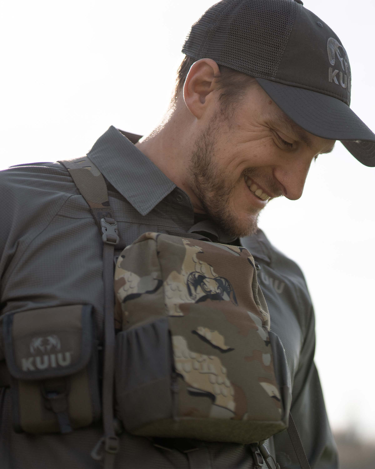 Hunter smiling, carrying a PRO Bino Harness on his chest, wearing Tiburon Hybrid Snap Shirt in Stone Grey