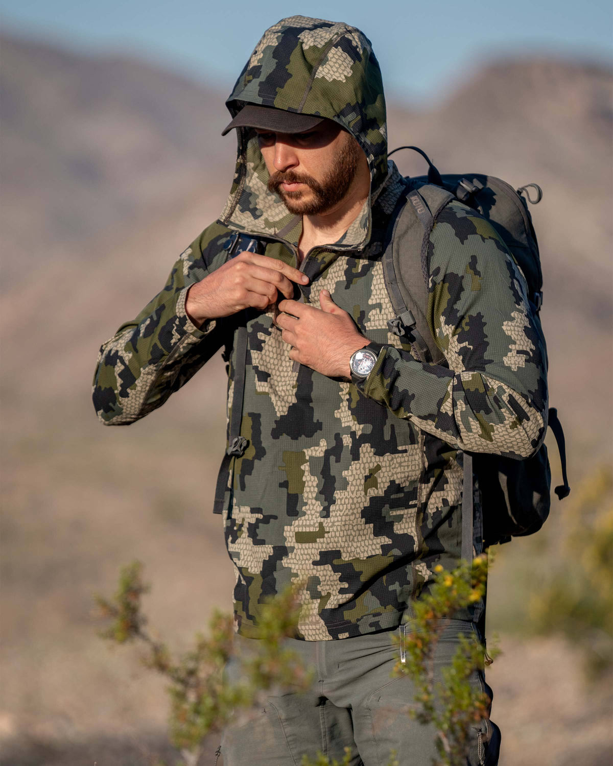 Hunter focused, zipping up Tiburon Hybrid Hoodie in Verde Camouflage
