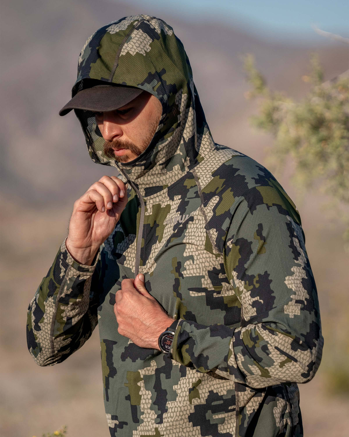 Hunter zipping up Tiburon Hybrid Hoodie in Verde Camouflage