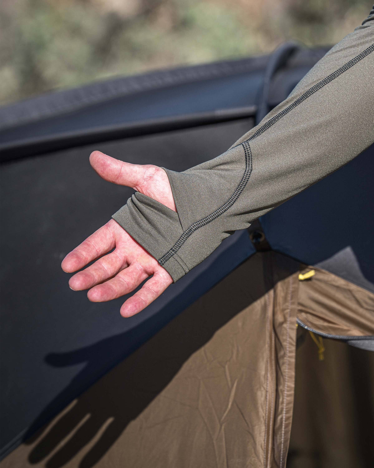 Close-up of a person displaying detail of layered thumbhole on Vital S3 Zip-T in Ash Brown.