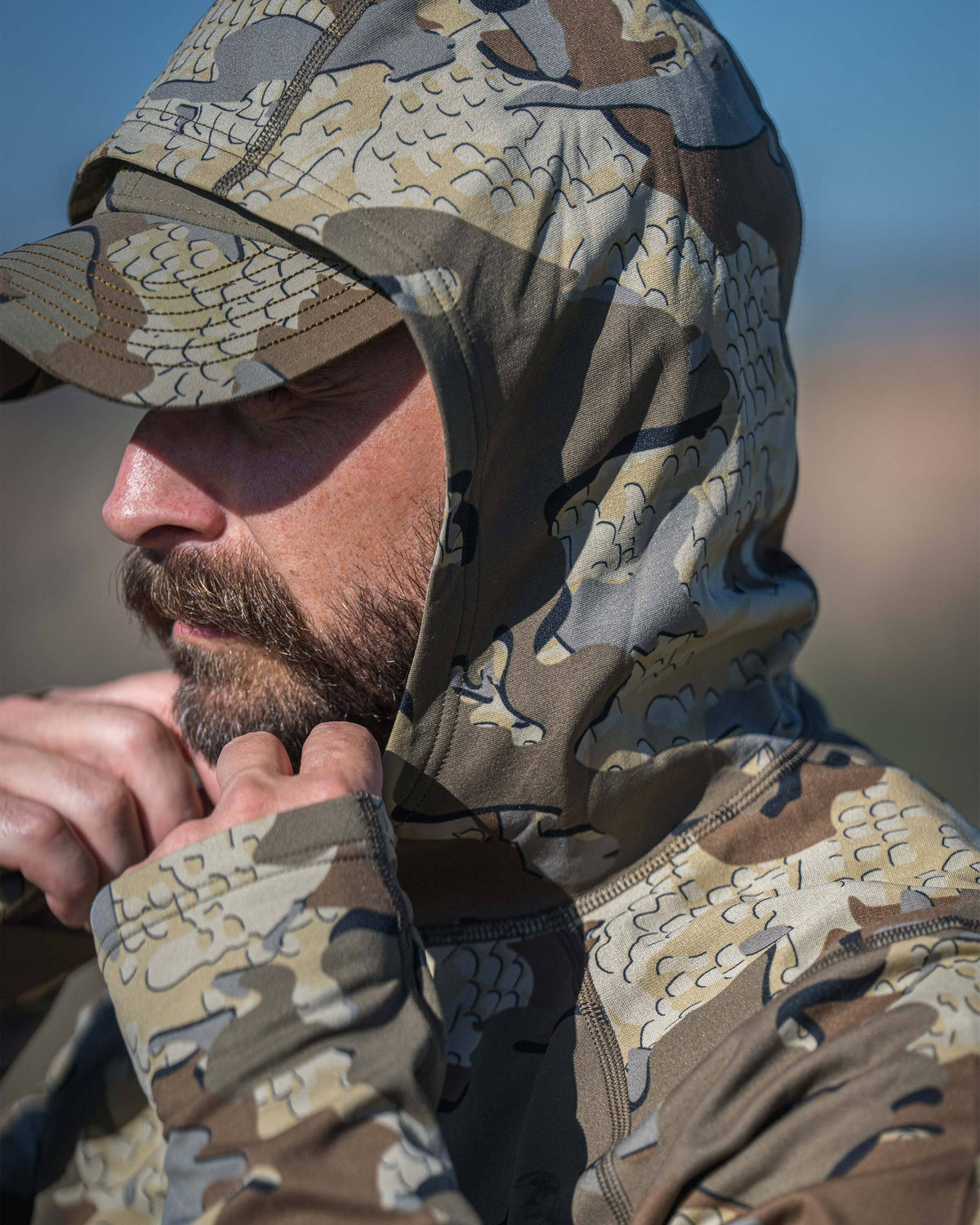 A close-up side profile of a man wearing a Vital S3 Zip-T Hoodie in Valo Camouflage with the fitted hood up.