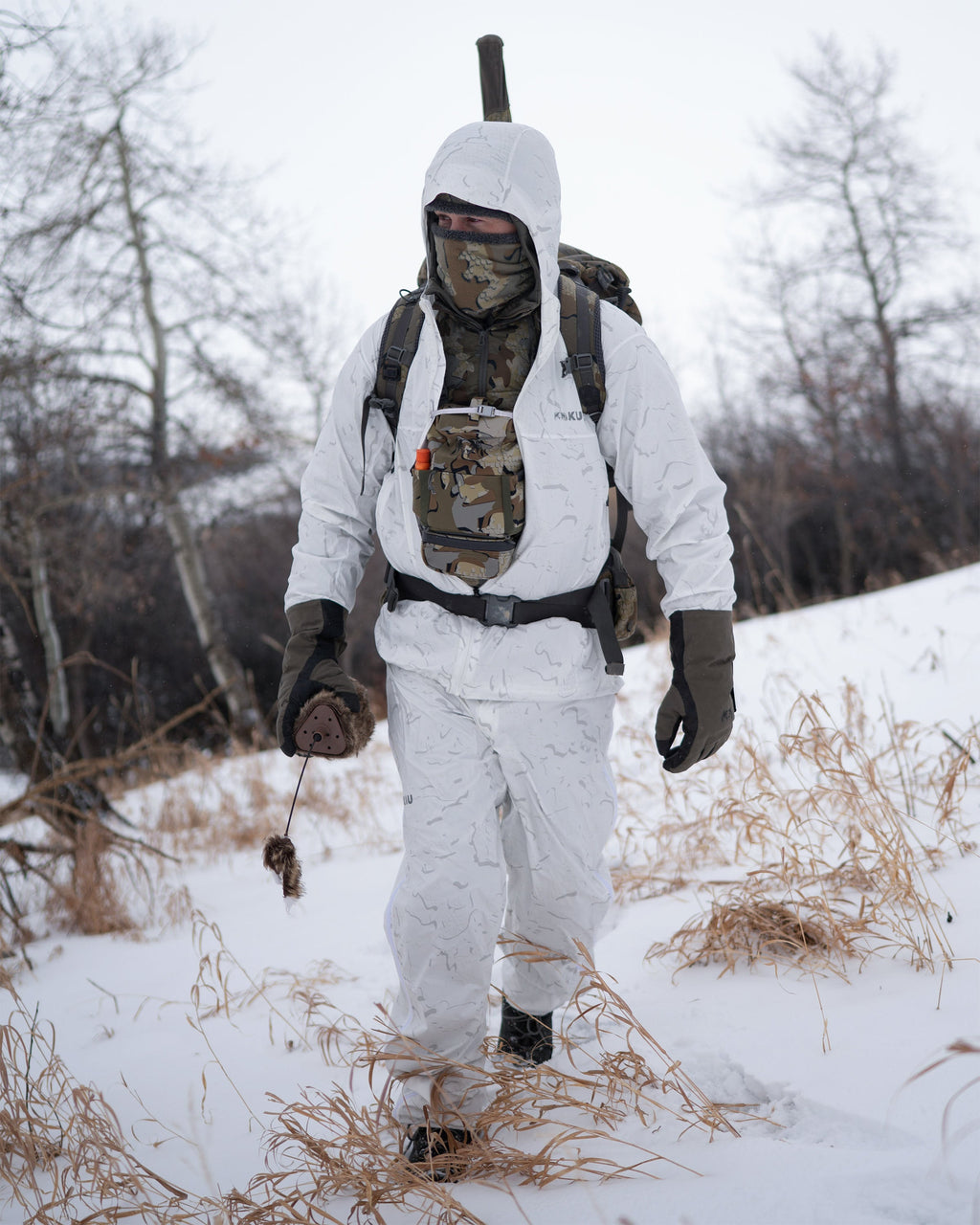 Hunter walks in a snow covered outdoor environment wearing Snowfall Overwhites Set