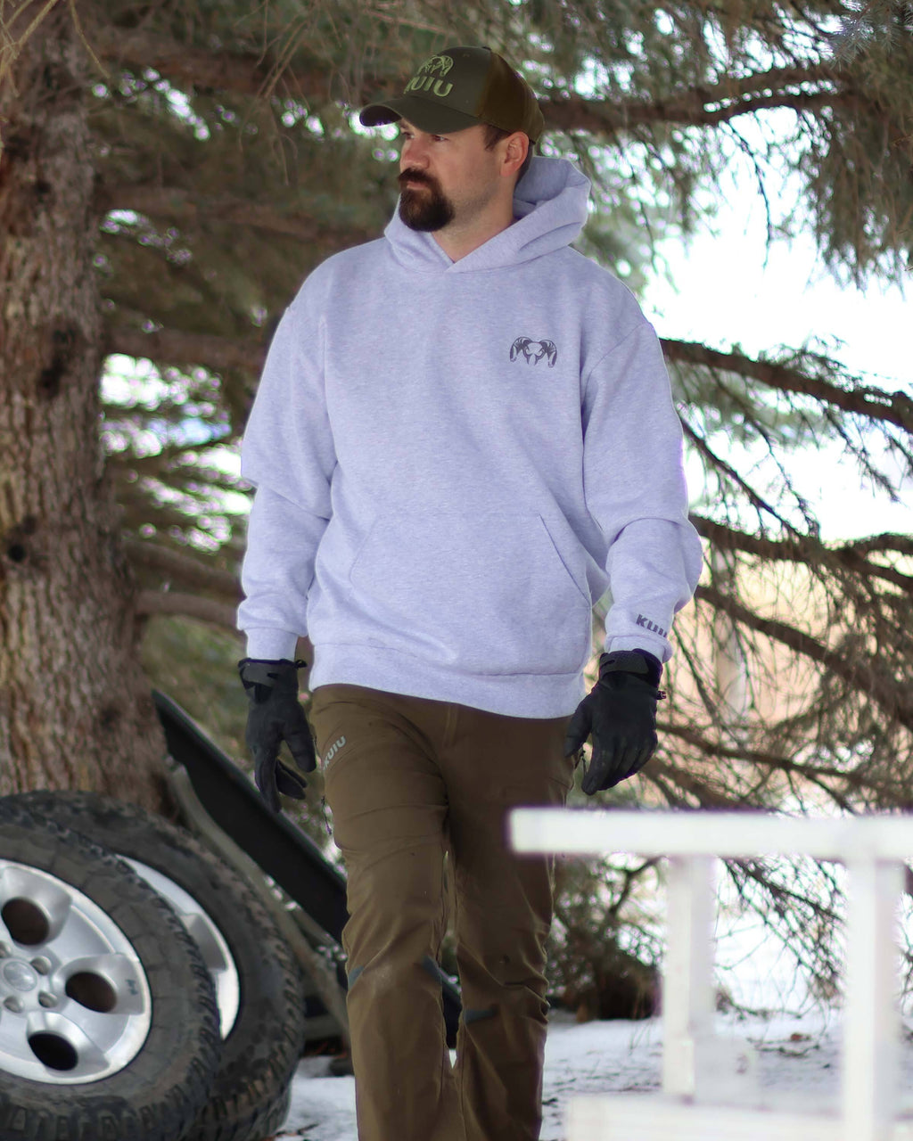Man in an outdoor setting, wearing Workgrade Heavyweight Hoodie in Heather Grey