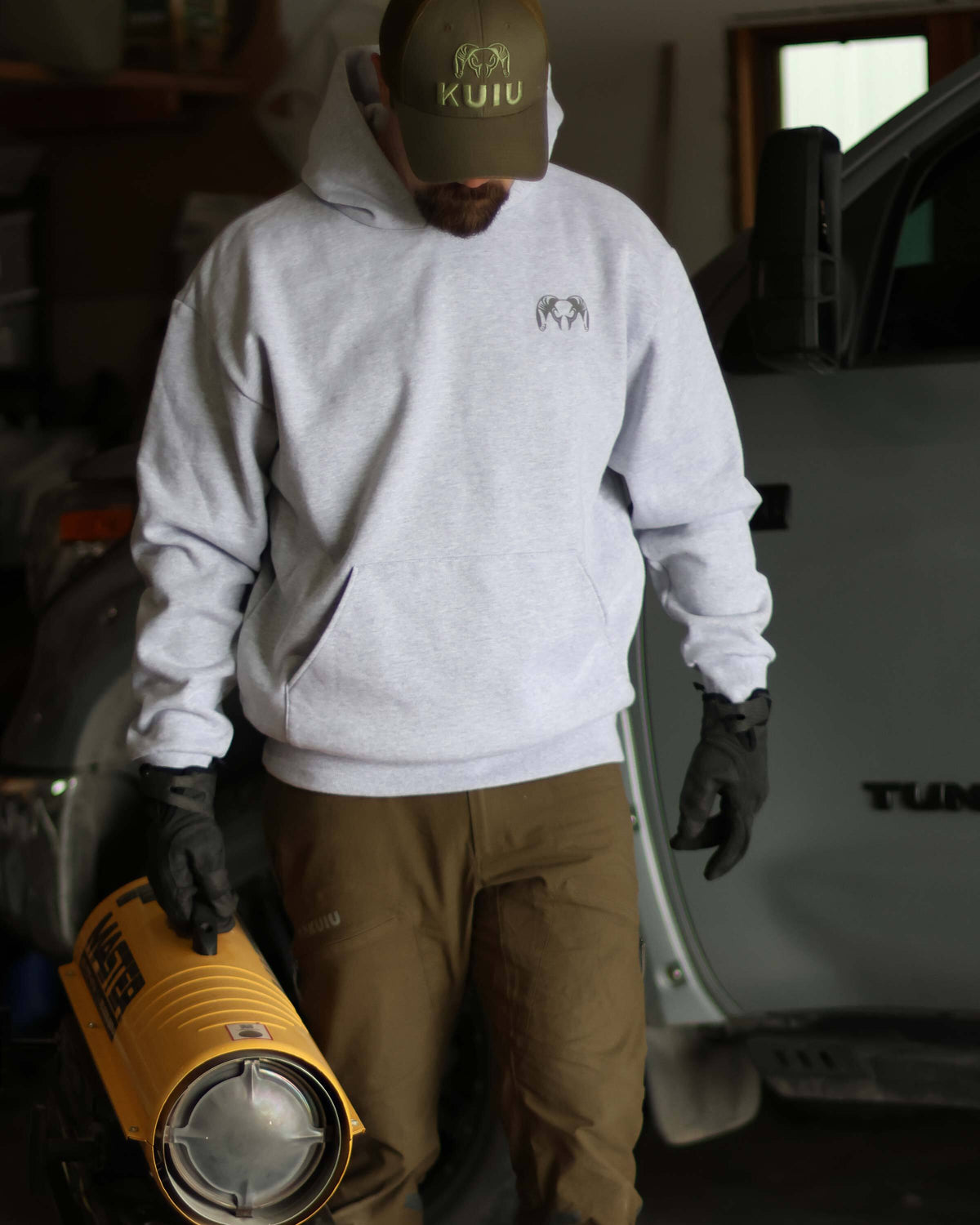 Man carrying a Master Diesel/Kerosene SilentDrive Forced Air Heater, wearing Workgrade Heavyweight Hoodie Heather Grey 