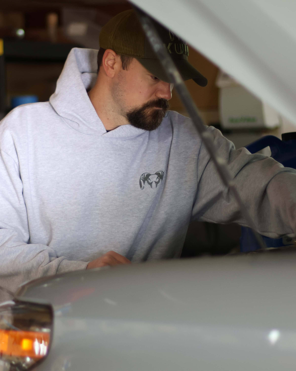 Man working under the car hood, wearing Workgrade Heavyweight Hoodie in Heather Grey