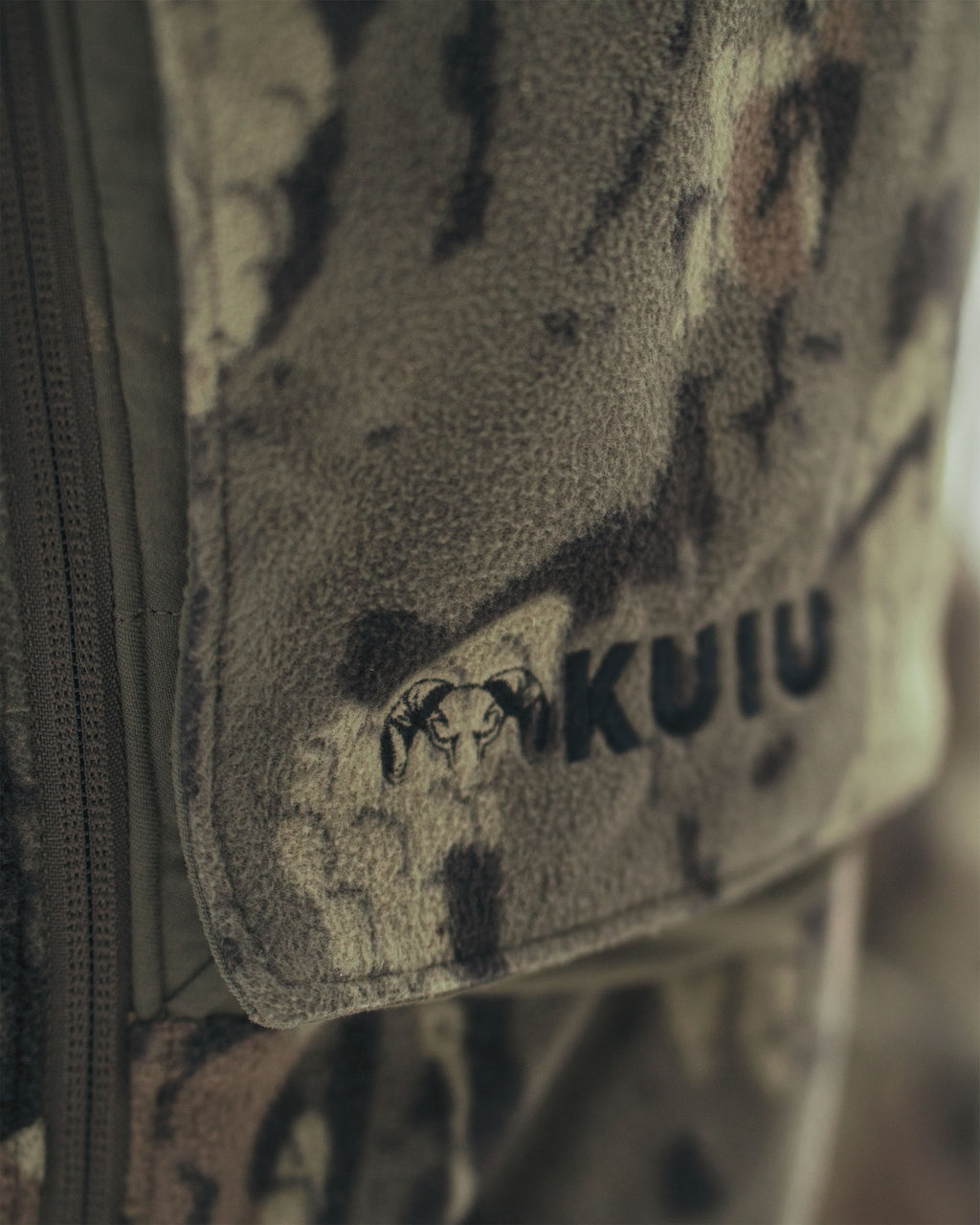 Close-up of Proximity Veros camouflage fabric pouch with a black embroidered ram head logo and the word 'KUIU' on the front.