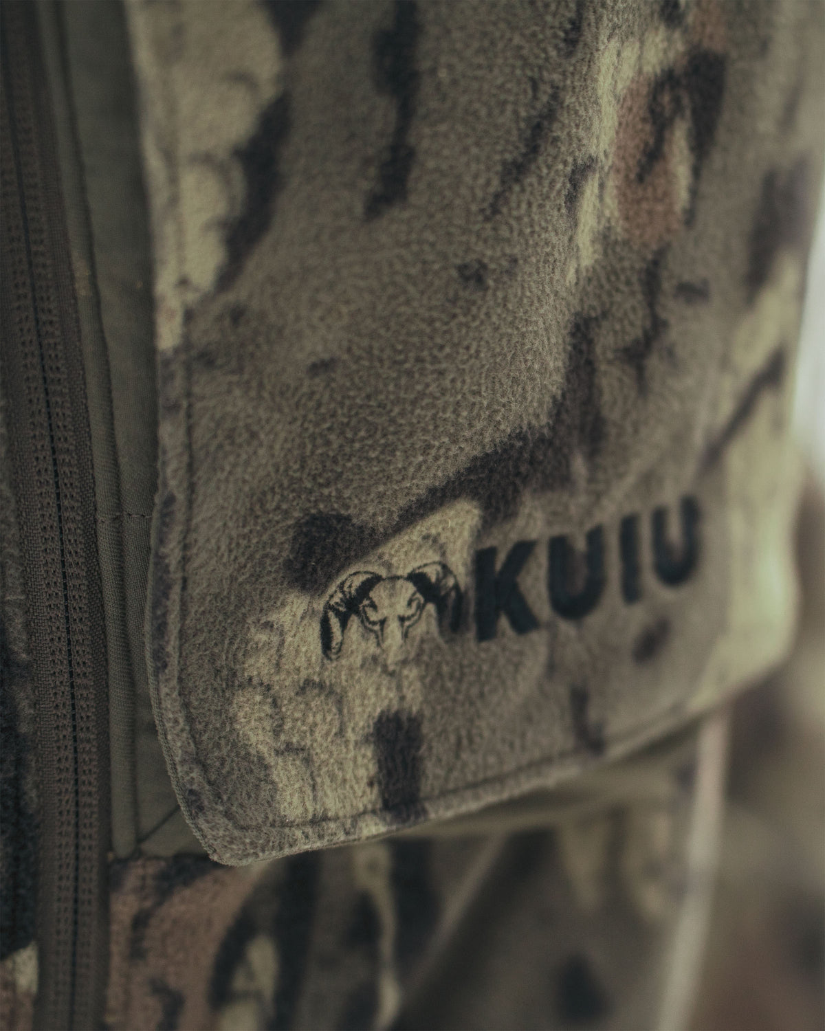Close-up of Proximity Veros camouflage fabric pouch with a black embroidered ram head logo and the word 'KUIU' on the front.