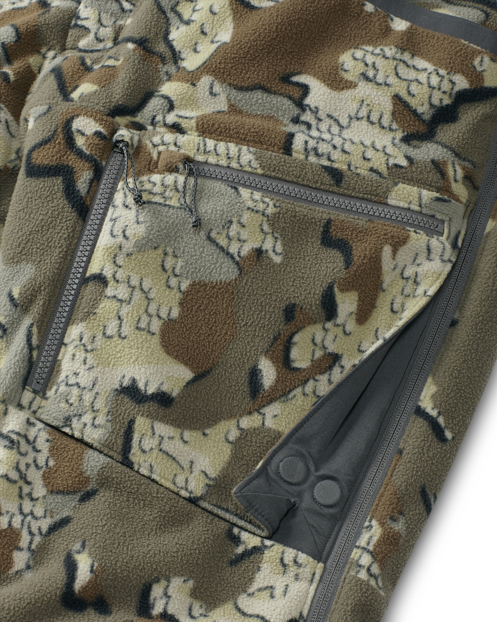 Close-up view of front zippered dual-compartment cargo pockets on the Proximity Insulated Pant in Valo Off-Shade