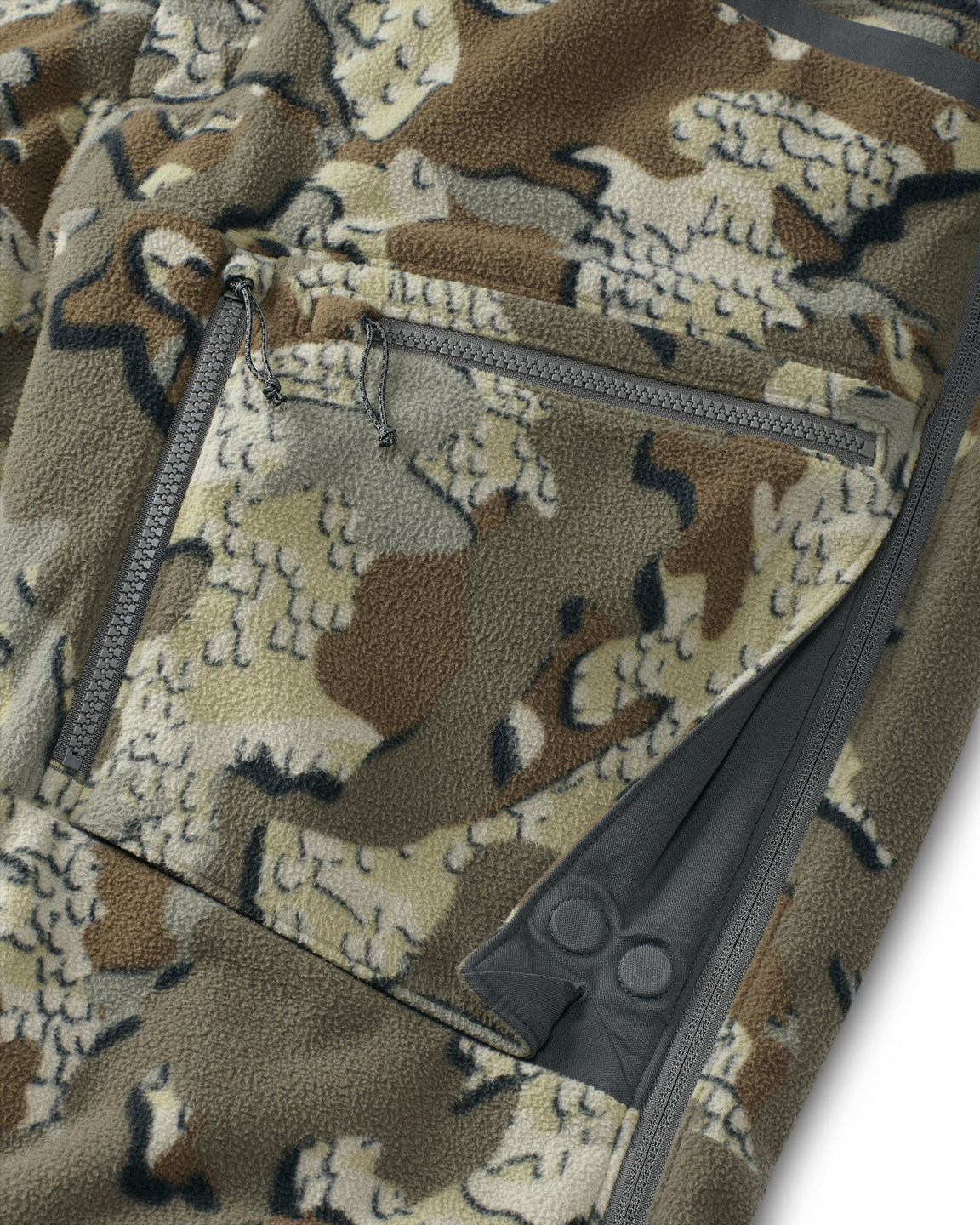 Close-up view of front zippered dual-compartment cargo pockets on the Proximity Insulated Pant in Valo Off-Shade