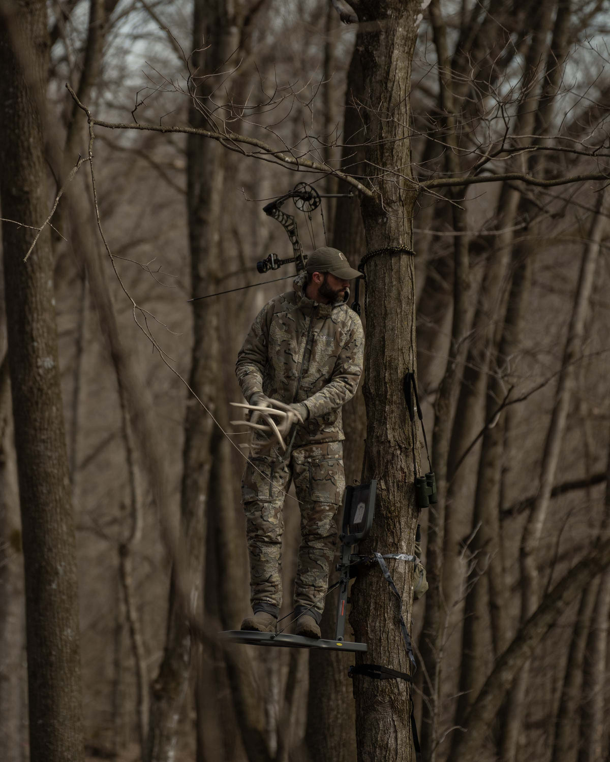 Front of Hunter Standing in Treestand Rattling Antlers Wearing Proximity Insulated Pants in Valo Off-Shade Camouflage