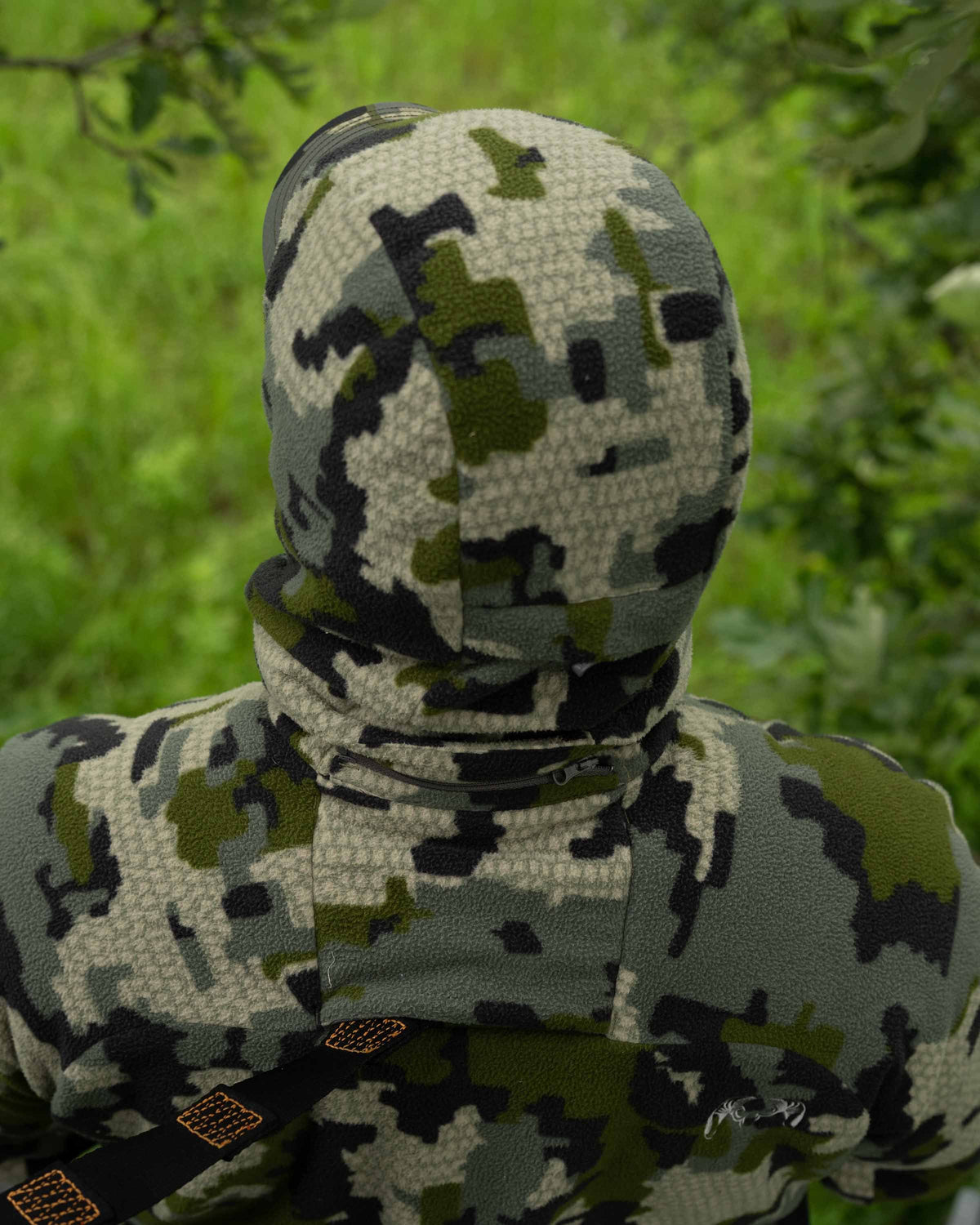 Back of Hunter in Treestand Wearing Proximity Hooded Insulated Jacket in Verde Camouflage Highlighting Treestand Safety Harness Port and Zip-off hood with magnetic connection points