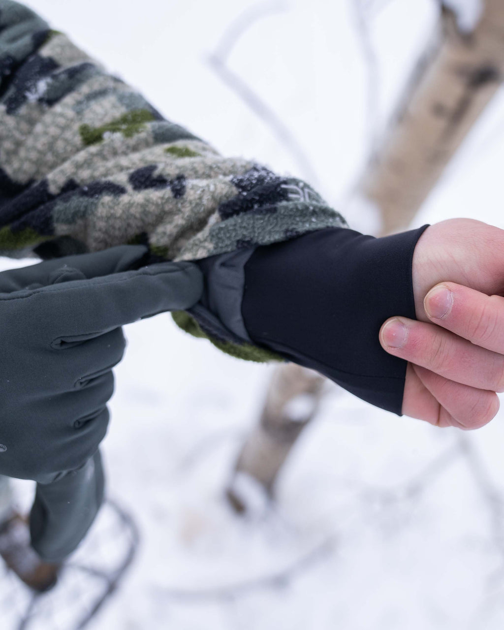 Front of Hunter Wearing Proximity Hooded Insulated Jacket in Verde Camouflage Highlighting Stretch Gasket Wrist Cuffs