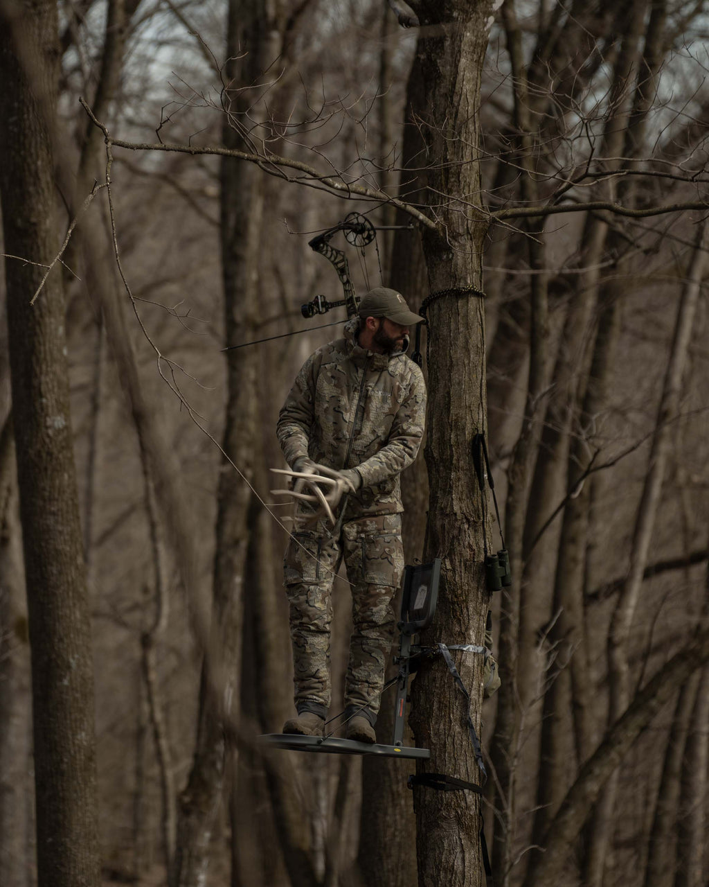 Front of Hunter in Treestand Rattling Antlers Wearing Proximity Hooded Insulated Jacket in Valo Camouflage