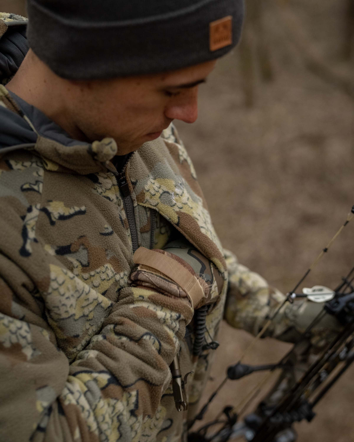 Front, Angled View of Hunter in Treestand Wearing Proximity Hooded Insulated Jacket in Valo Camouflage Highlighting YKK Zippered Chest Pocket