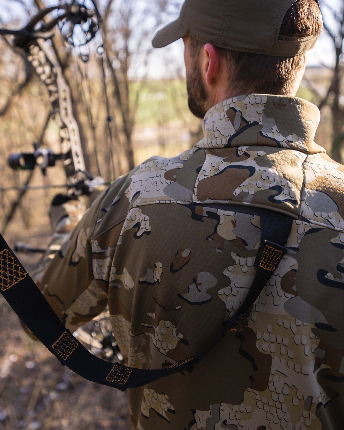 Detail back hunter wearing Encounter Jacket in Valo Camouflage using the layered safety harness port