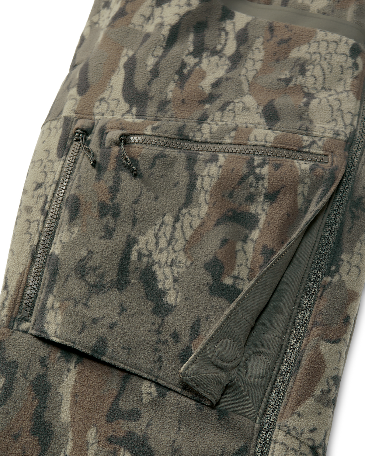 Close-up of a thigh pockets on the KUIU Proximity Insulated Bib in Veros camouflage showing a zippered pocket with dual zipper pulls and a magnetic gusset closures to keep cargo pockets streamlined.